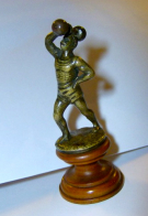 Small strongmen figure with movable dumbbell (metal sculpture on wooden podest ca. 1910)